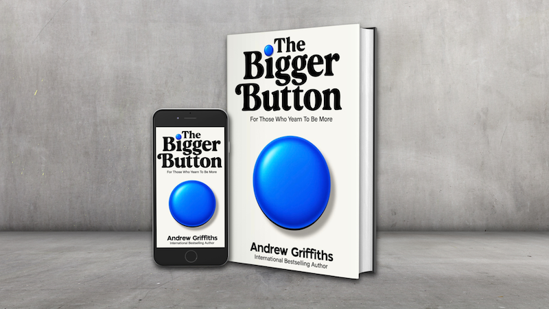 A book with title The Bigger Button, against a grey wall background