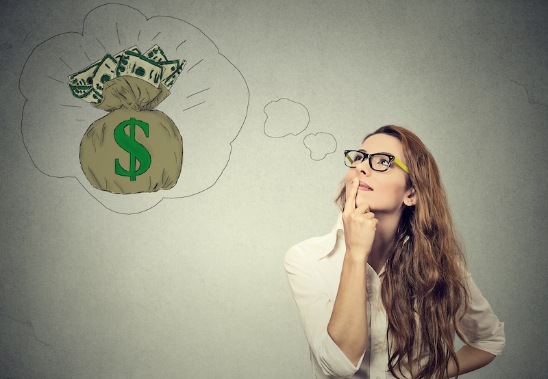 Woman looks at a bag of dollars thinking about how to make money