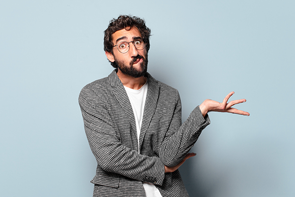 man with grey jacket with a questioning look on his face against a blue background